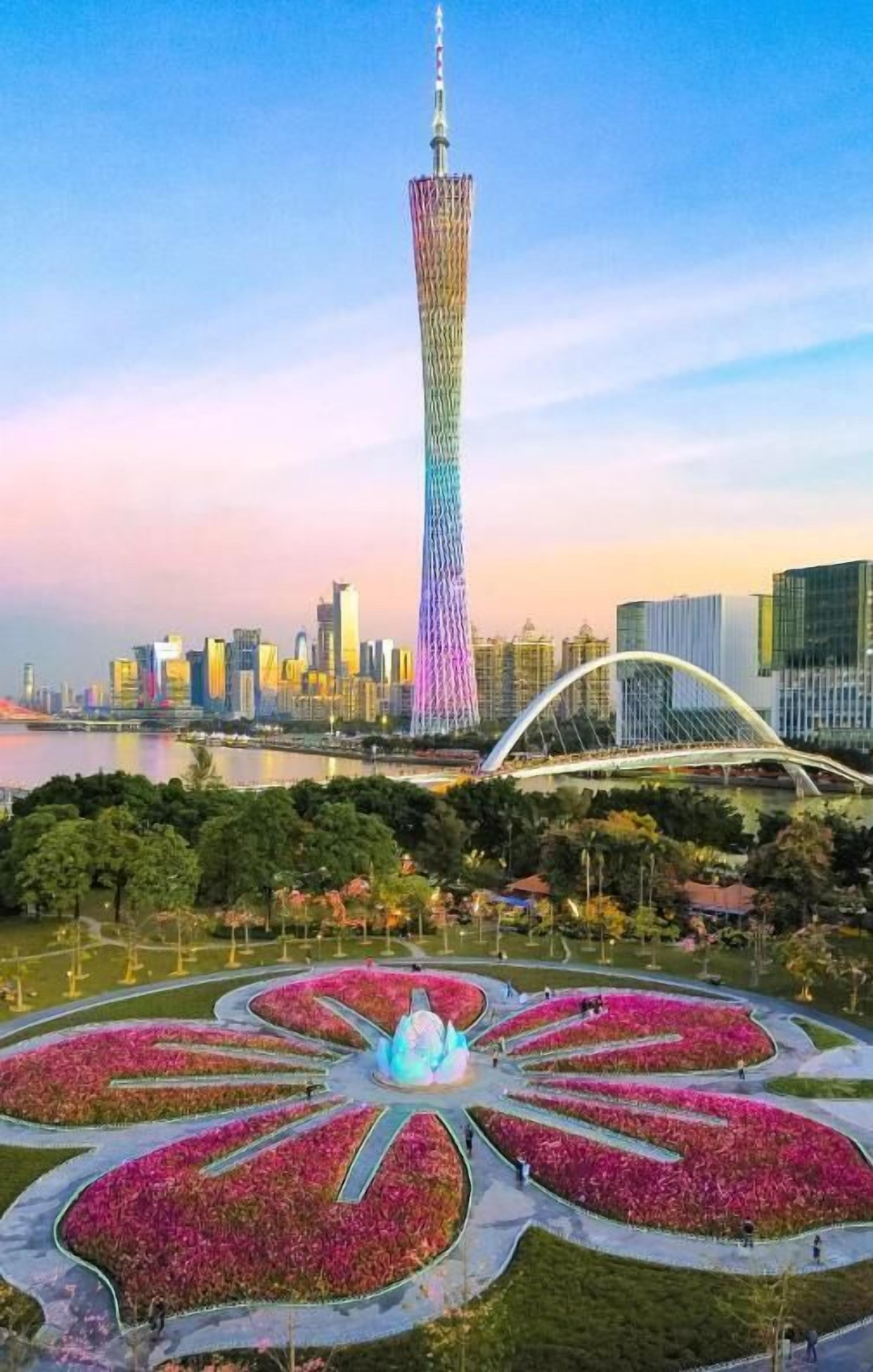 Un paisaje urbano con una torre destacada, un puente y un parque con forma de flor.