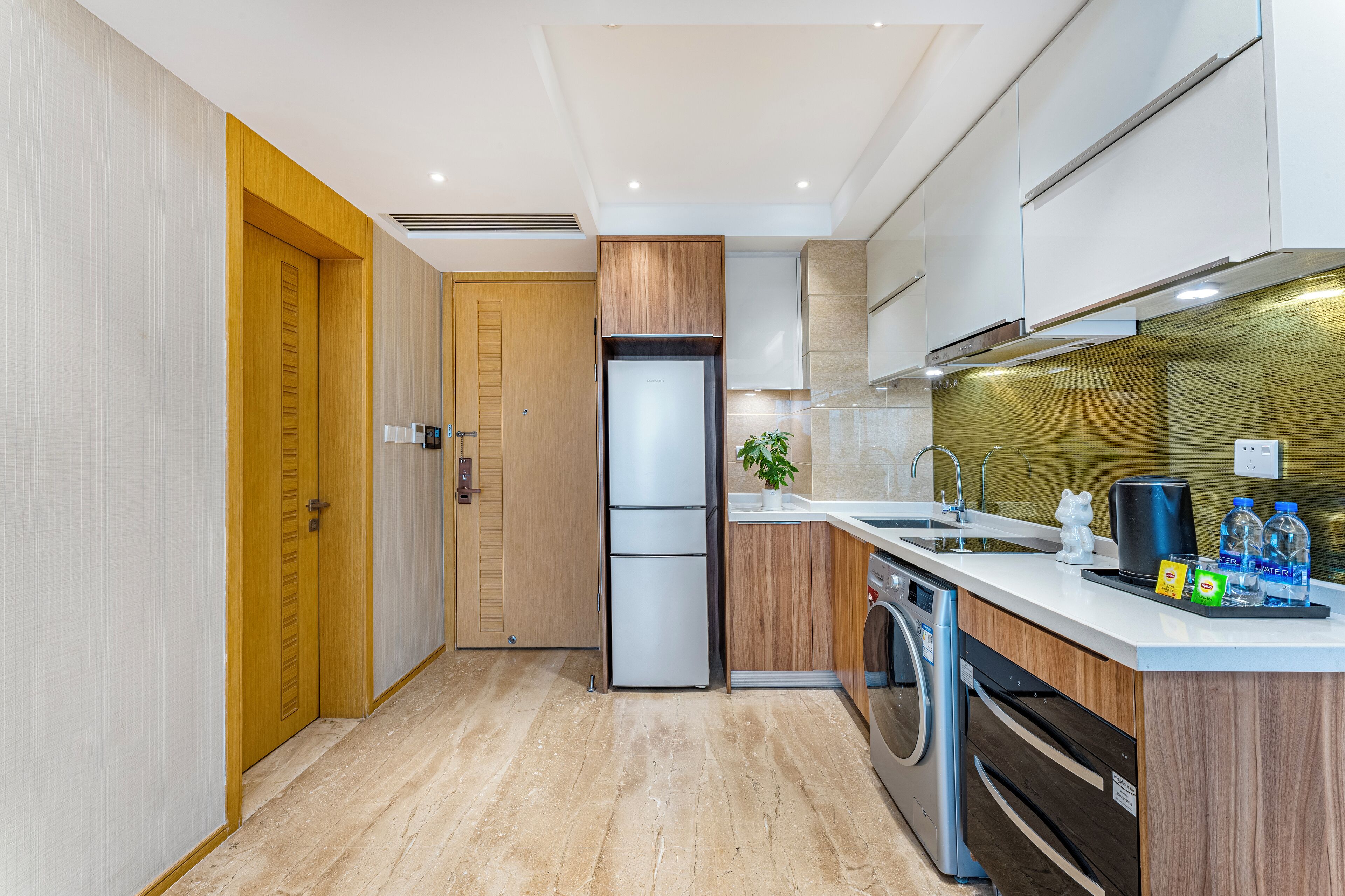 A modern kitchen with wooden cabinets, a built-in oven, a sink, and a dishwasher.