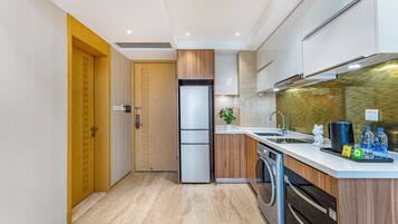 A modern kitchen with wooden cabinets, a built-in oven, a sink, and a dishwasher.