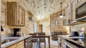 A wooden cabin interior with a kitchen, dining area, and living space. - Little Haven Cottage-Pickleball Court, WIFI, budget friendly (Cosby)