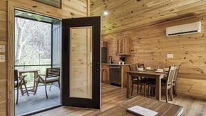 A wooden interior with a dining area, kitchen, and a sliding glass door leading to an outdoor space. - Little Haven Cottage-Pickleball Court, WIFI, budget friendly (Cosby)
