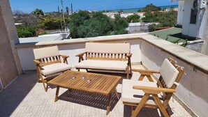 An outdoor patio with wooden furniture and a view of the sea. - Villa Irene Nice Seaview (Lecce)