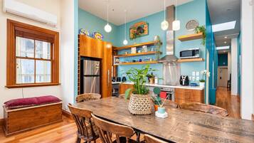 Une cuisine moderne avec une table à manger en bois, des chaises et un réfrigérateur encastré.