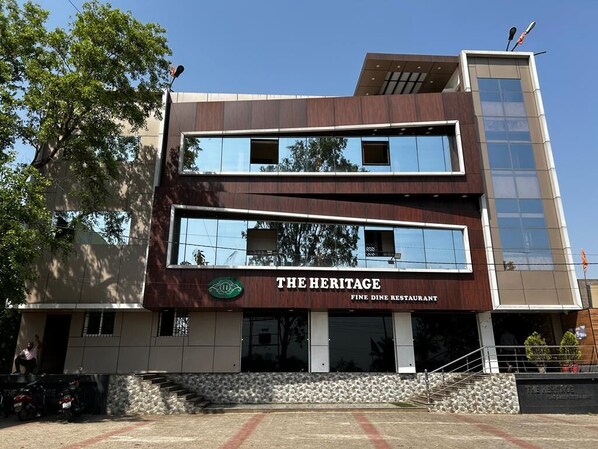 Un edificio de dos pisos con un letrero que dice 'THE HERITAGE FINE DINE RESTAURANT'.