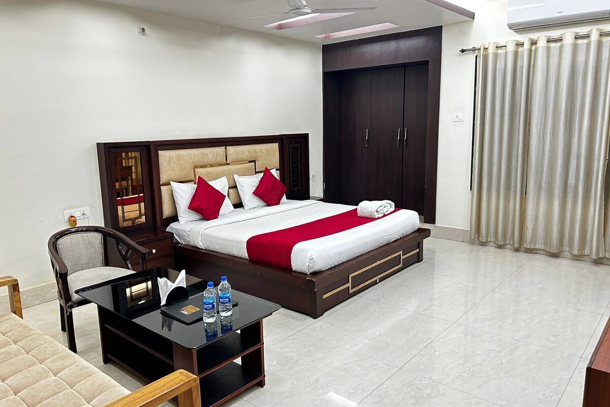 A hotel room with a bed, a nightstand, a desk, and a chair.