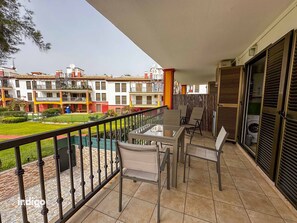 Ein Balkon mit Gartenmöbeln, Blick auf ein Wohngebiet und ein Gebäude mit Balkonen.