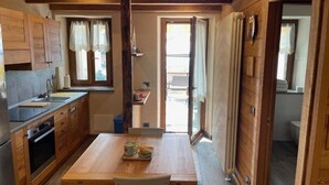Une cuisine de taille réduite, dotée de meubles en bois, d’un évier et d’une table à manger avec des chaises.