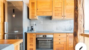Une cuisine moderne avec des meubles en bois, un réfrigérateur en acier inoxydable, un four et un évier.