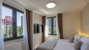 A hotel room with a large bed, a flat-screen TV, and a window with curtains. - Nobel West Hotel (Belgrade)