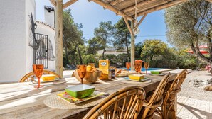 A wooden dining table set with various bowls, glasses, and a bottle of Don Simon wine. - Quiet 3 Bedroom Family Villa (Javea / Xàbia)