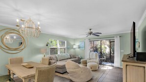 A spacious living area with a dining table, two sofas, and a ceiling fan. - MIDDLE OF 30A! MINUTES FROM BEACH, POOLS, TENNIS COURTS and NATURE TRAILS! (Santa Rosa Beach)