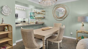 A dining room with a wooden table, two chairs, a chandelier, and a large mirror on the wall. - MIDDLE OF 30A! MINUTES FROM BEACH, POOLS, TENNIS COURTS and NATURE TRAILS! (Santa Rosa Beach)