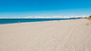 A wide, sandy beach with a clear blue sky. - Beachfront, Breathtaking Gulfviews with Resort Pool and Spectacular Sunsets. (HOLMES BEACH)