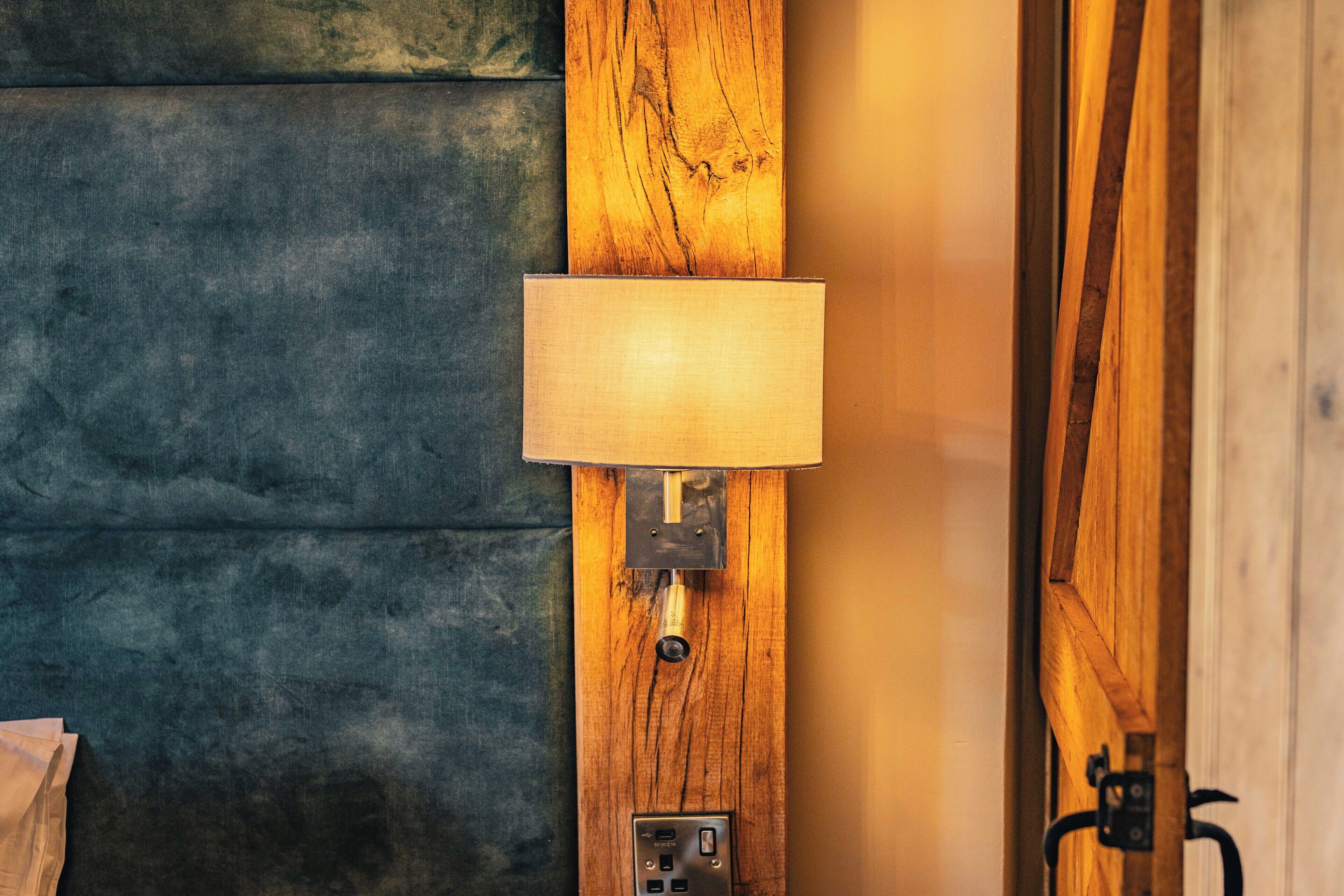A wall-mounted lamp with a wooden panel and a switch.