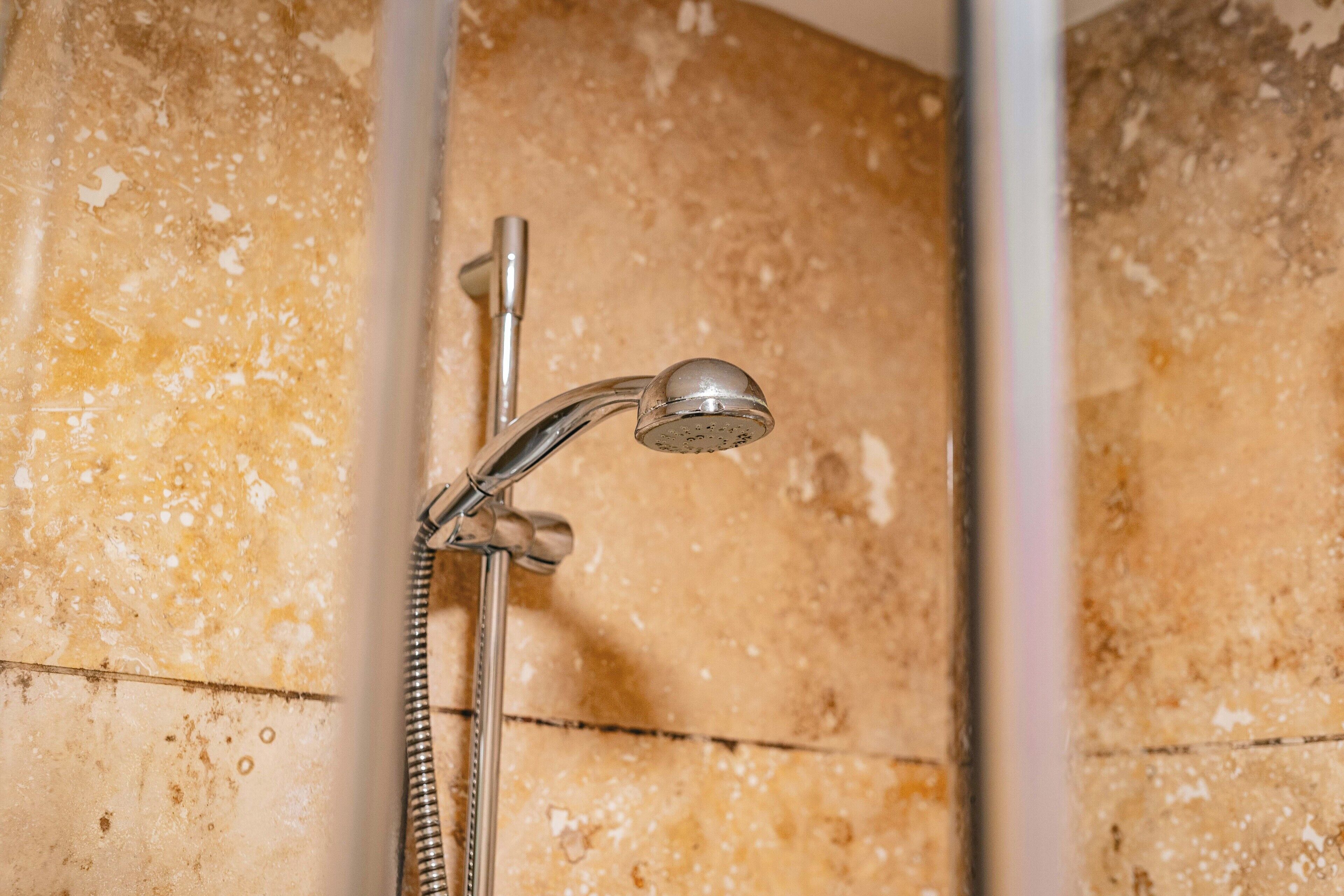 A shower with a handheld showerhead and a flexible hose.
