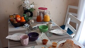 Ett frukostbord med frukt, bröd och drycker.