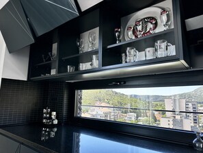 A modern kitchen with a large window overlooking a cityscape.