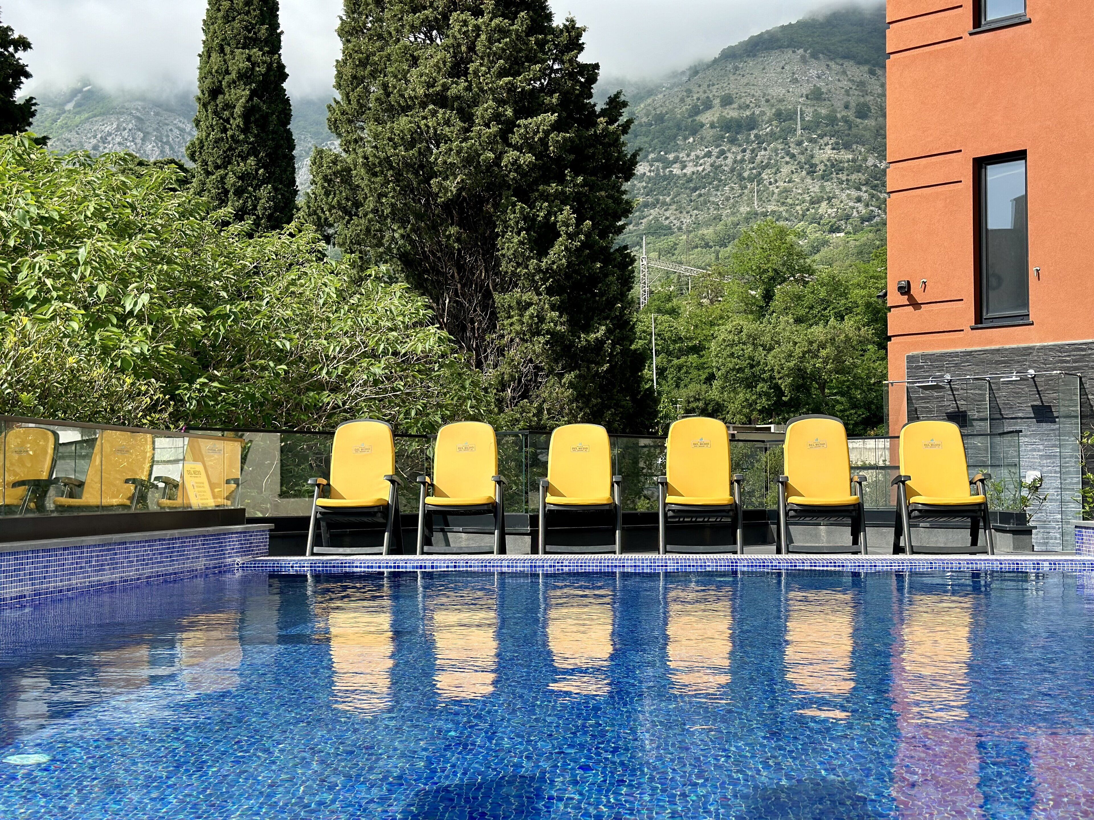 A pool area with yellow chairs and a tiled edge.
