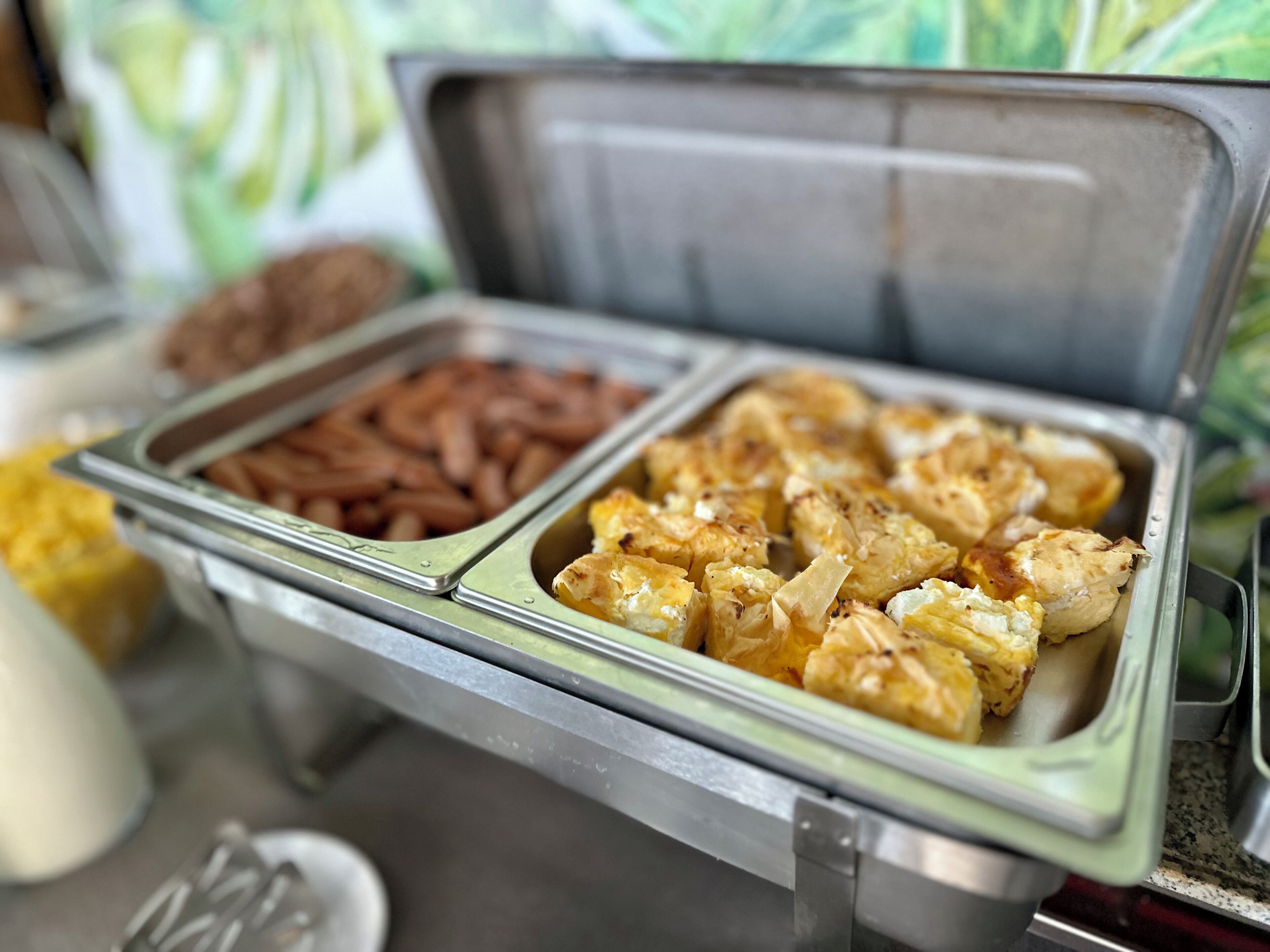 A buffet with various food items including what appears to be chicken and possibly other meats.