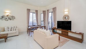 Una sala moderna con sofá, mesa de comedor y televisor.