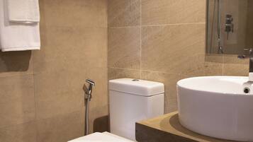 Un baño con inodoro, lavamanos y ducha.