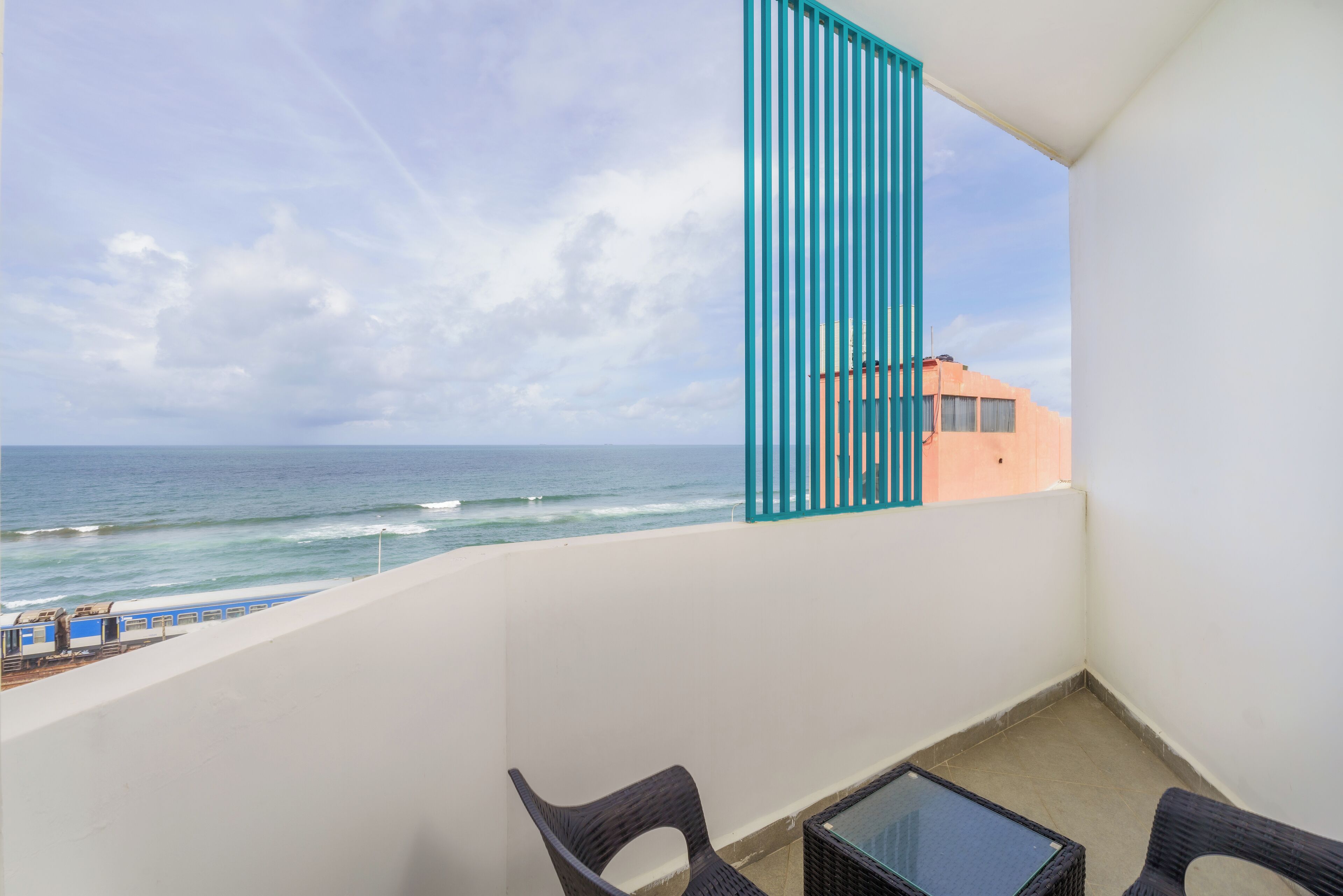 Un balcone con vista sull'oceano, un tavolo e due sedie.