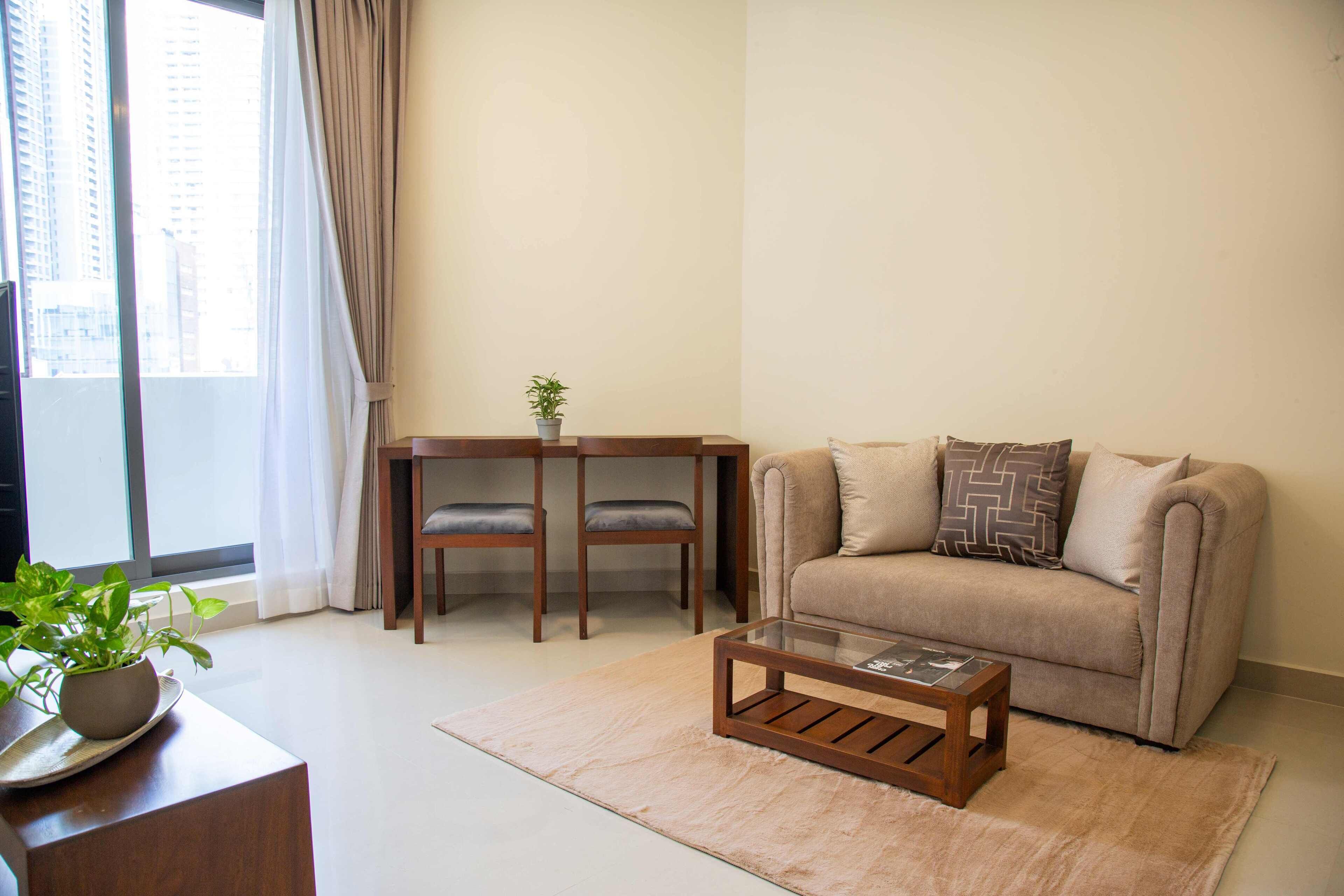 A modern living room with a sofa, a coffee table, and a small table with chairs.