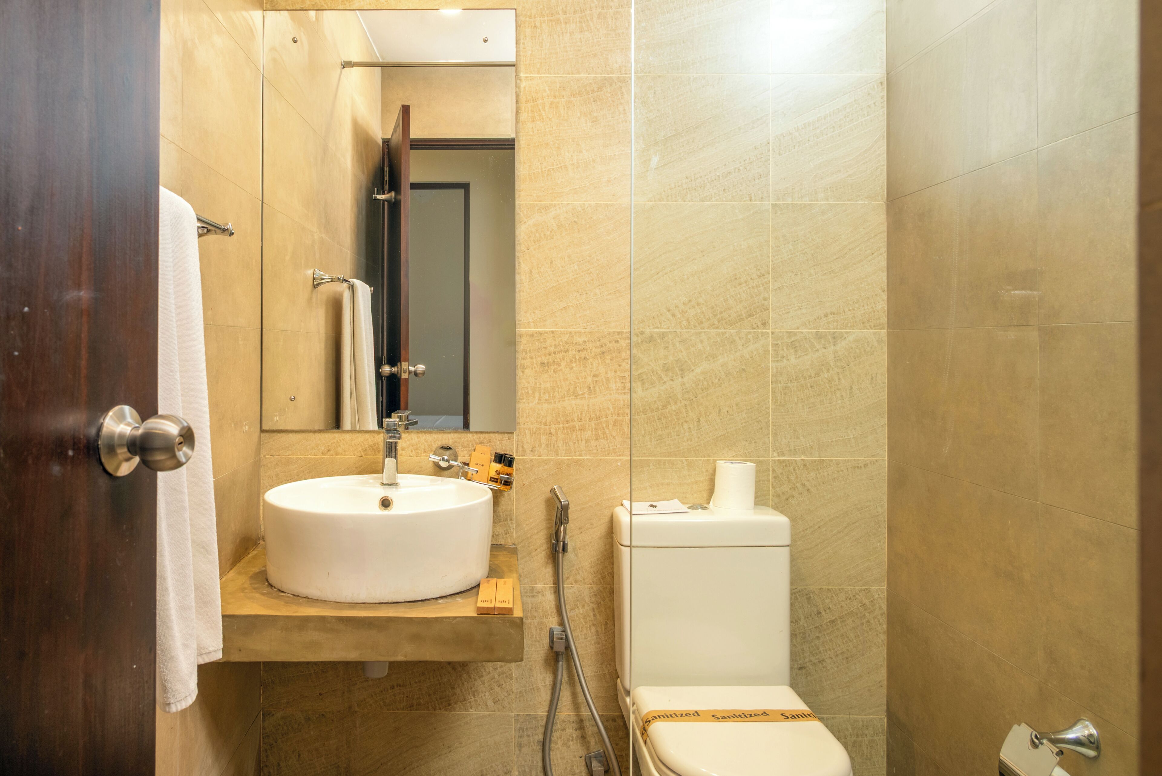 A bathroom with a sink, mirror, toilet, and towel rack.