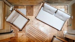 A modern bathroom with two wooden benches, a bathtub, and a shower area. - A Unique and Charming Farmhouse with Heated Pool. (L-Gnasri)