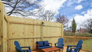 Eine Terrasse im Freien mit Holzmöbeln, darunter Stühle und ein Tisch.
