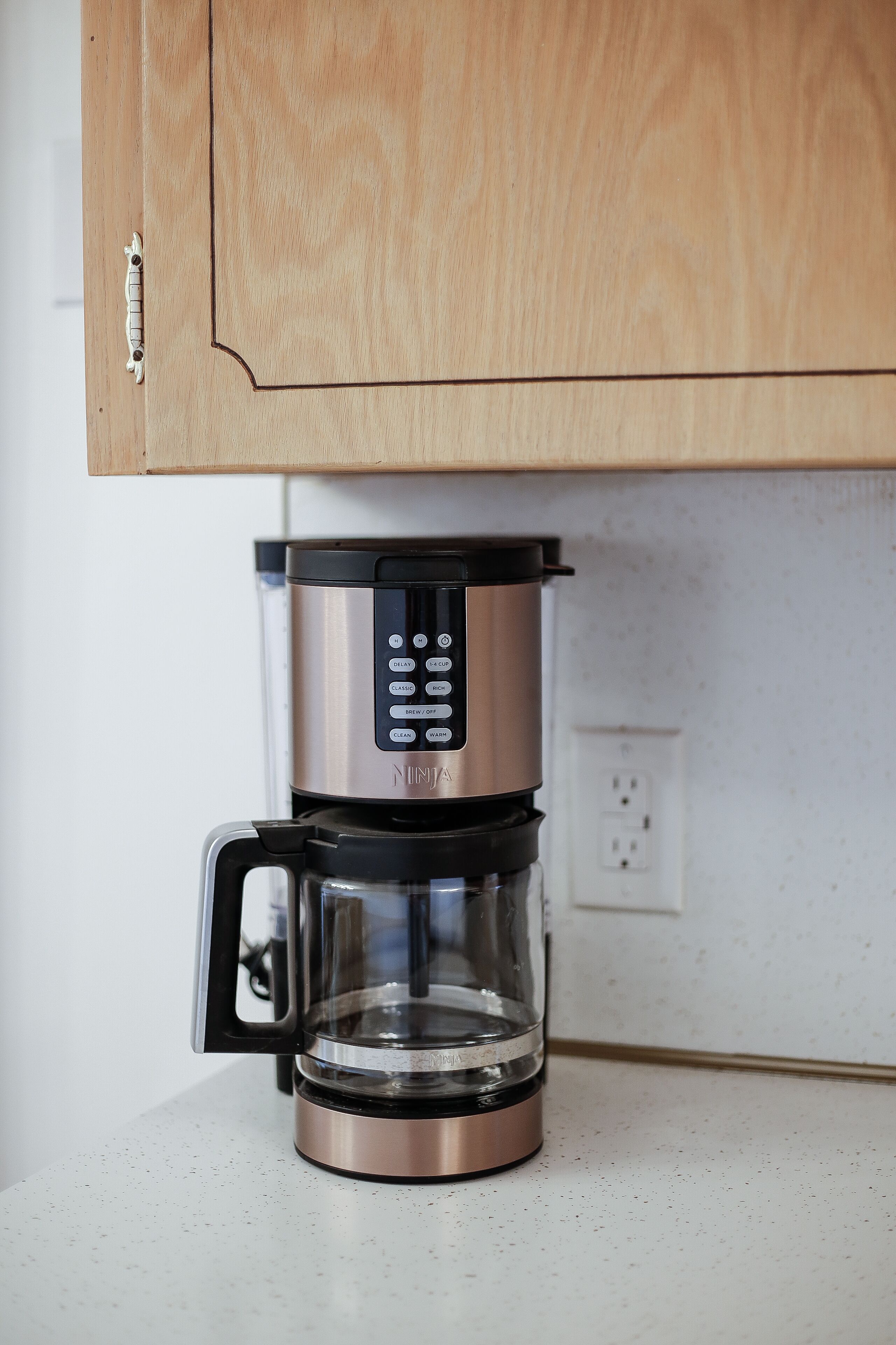 Una cafetera con pantalla digital sobre una encimera.