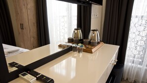 A hotel room with a large mirror, a minibar, a coffee maker, and a remote control on the counter. - SULTAN SÜLEYMAN  APART HOTEL (Istanbul)