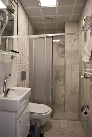 A modern bathroom with a shower, toilet, and sink. - SULTAN SÜLEYMAN  APART HOTEL (Istanbul)