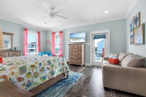 Quarto com cama, cômoda e vista para o exterior.