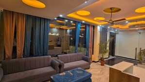 A modern hotel lobby with a sofa set, a coffee table, and a reception desk. - Trevon The Shire Inn (Haldwani)