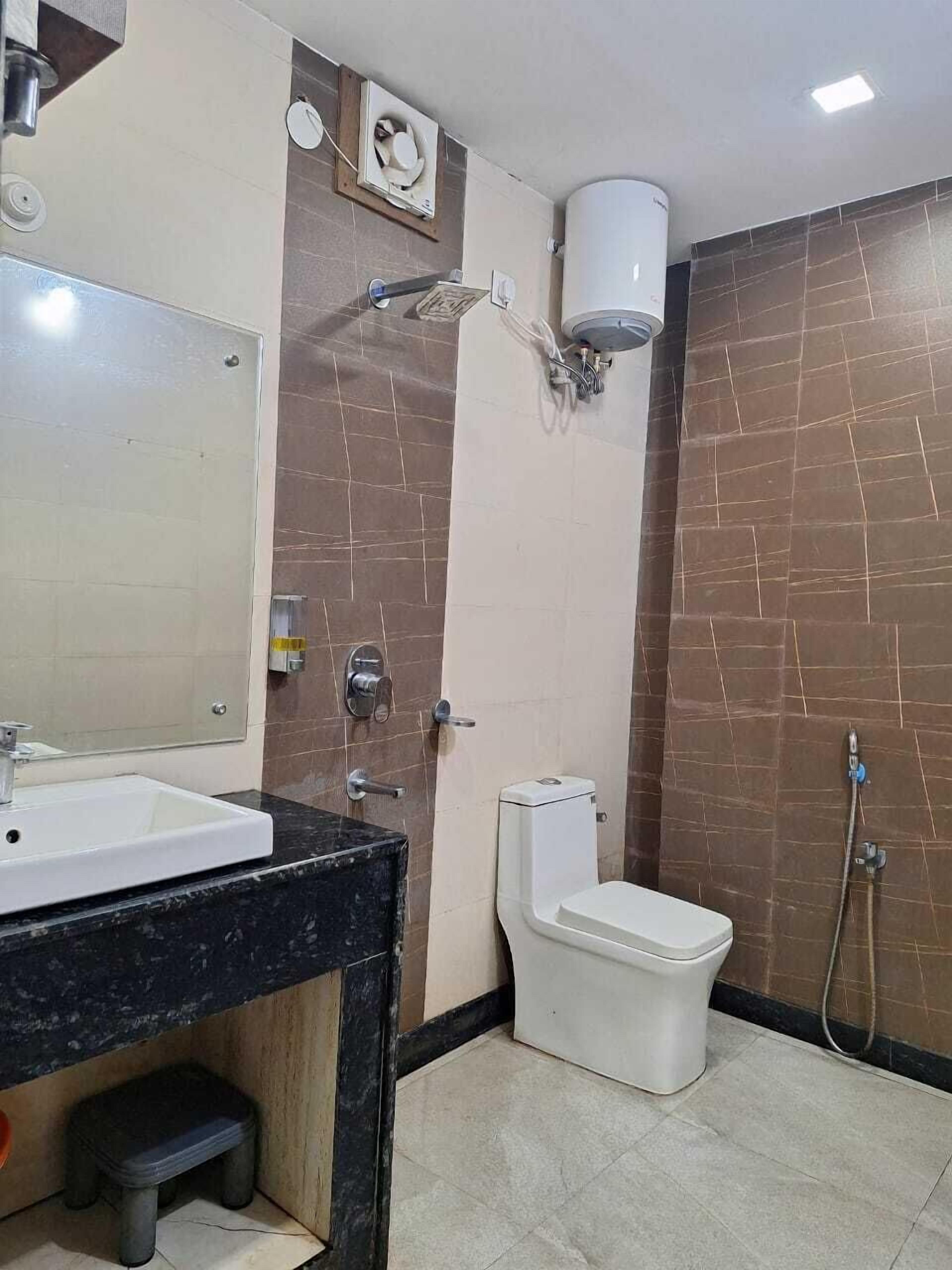 Uma casa de banho com lavatório, sanita e chuveiro.