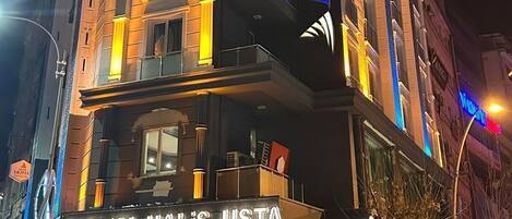 A hotel with a prominent sign reading "AKAR HOTEL" and a ground-level shop named "TATLICI HALIS USTA".