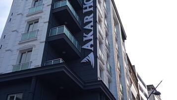 A multi-story building with the sign "AKAR HOTEL" prominently displayed.