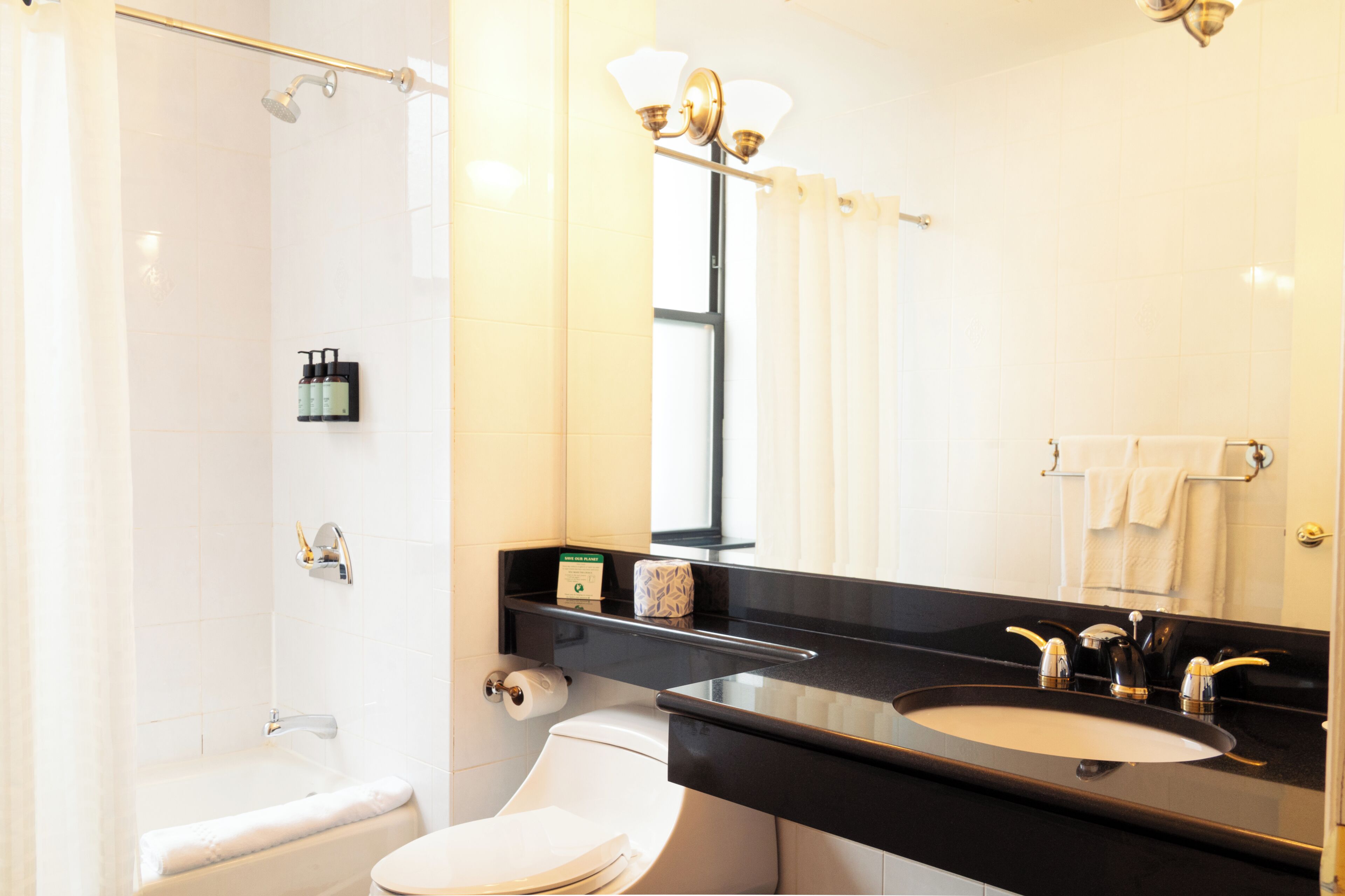 A bathroom with a bathtub, toilet, sink, and a mirror.