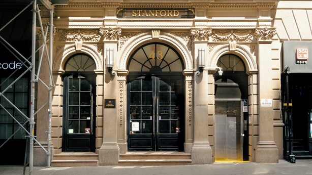 A building facade with the name 'STANFORD' above the entrance, a set of double doors, and an elevator. - Hotel Stanford (New York)