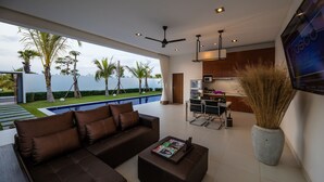 A modern living room with a sofa, coffee table, and a TV mounted on the wall. - Angkor Rendezvous (Siem Reap)