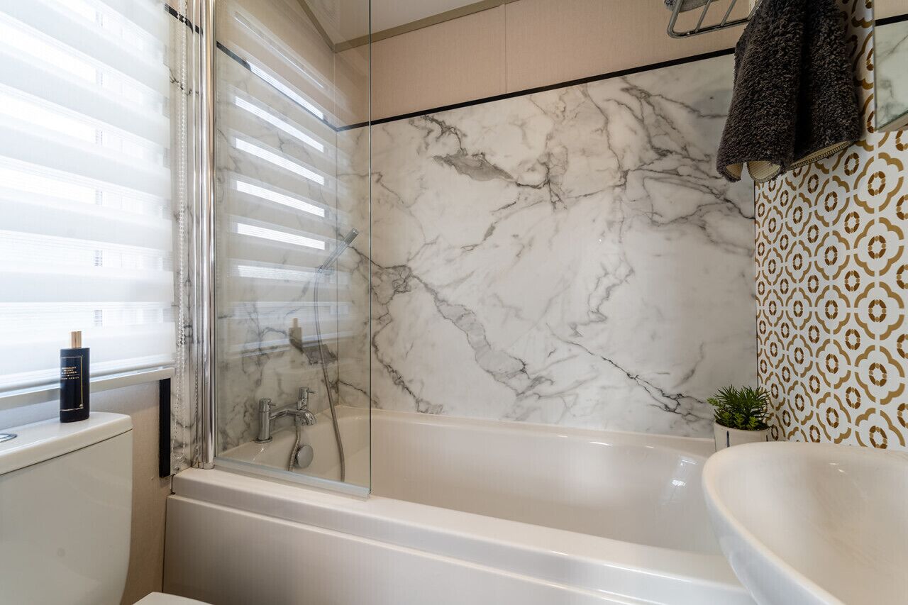 Une salle de bain avec une baignoire, une douche à parois de verre et un lavabo.
