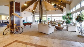 A spacious lobby with a high ceiling, wooden beams, and large windows. - Lakeside Osage Beach Condo in Lands End Community (Osage Beach)