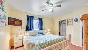 A bedroom with a bed, nightstands, a ceiling fan, and a window with curtains. - Downtown Williams Home: Walk to Shops & Dining! (Williams)