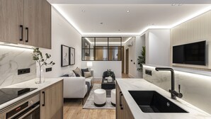 Una cocina moderna con electrodomésticos integrados, una isla central y un televisor empotrado.