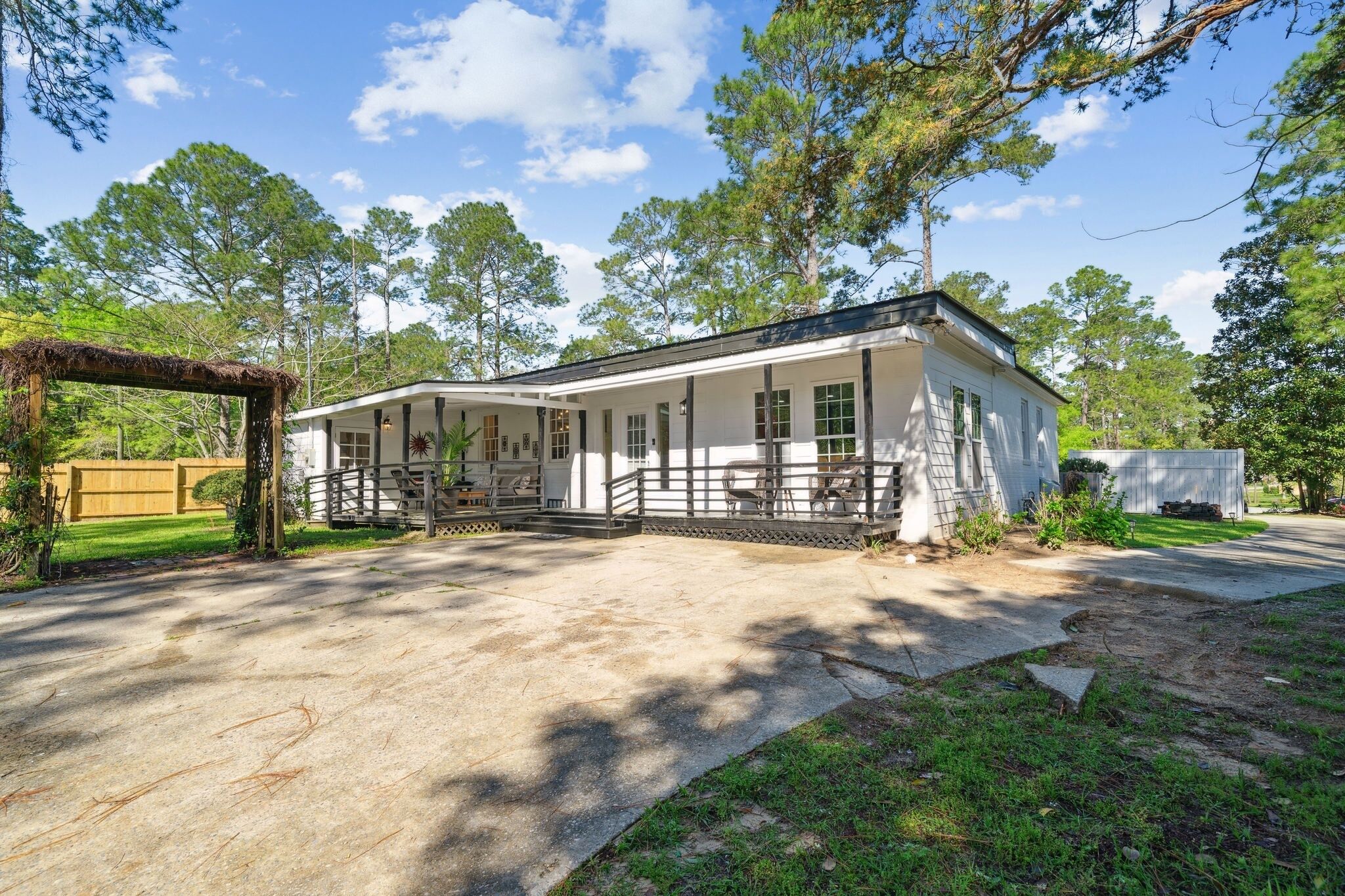 A two-story house with a covered porch and a fenced yard.