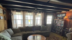 Ein gemütliches Wohnzimmer mit einer Eckcouch, einem Couchtisch und einem Bücherregal.