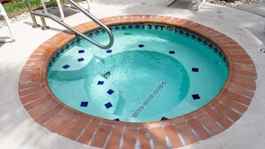 A small, circular hot tub with a brick border and a metal ladder. - Surfside I #304 2 Bedroom Condo by RedAwning (South Padre Island)