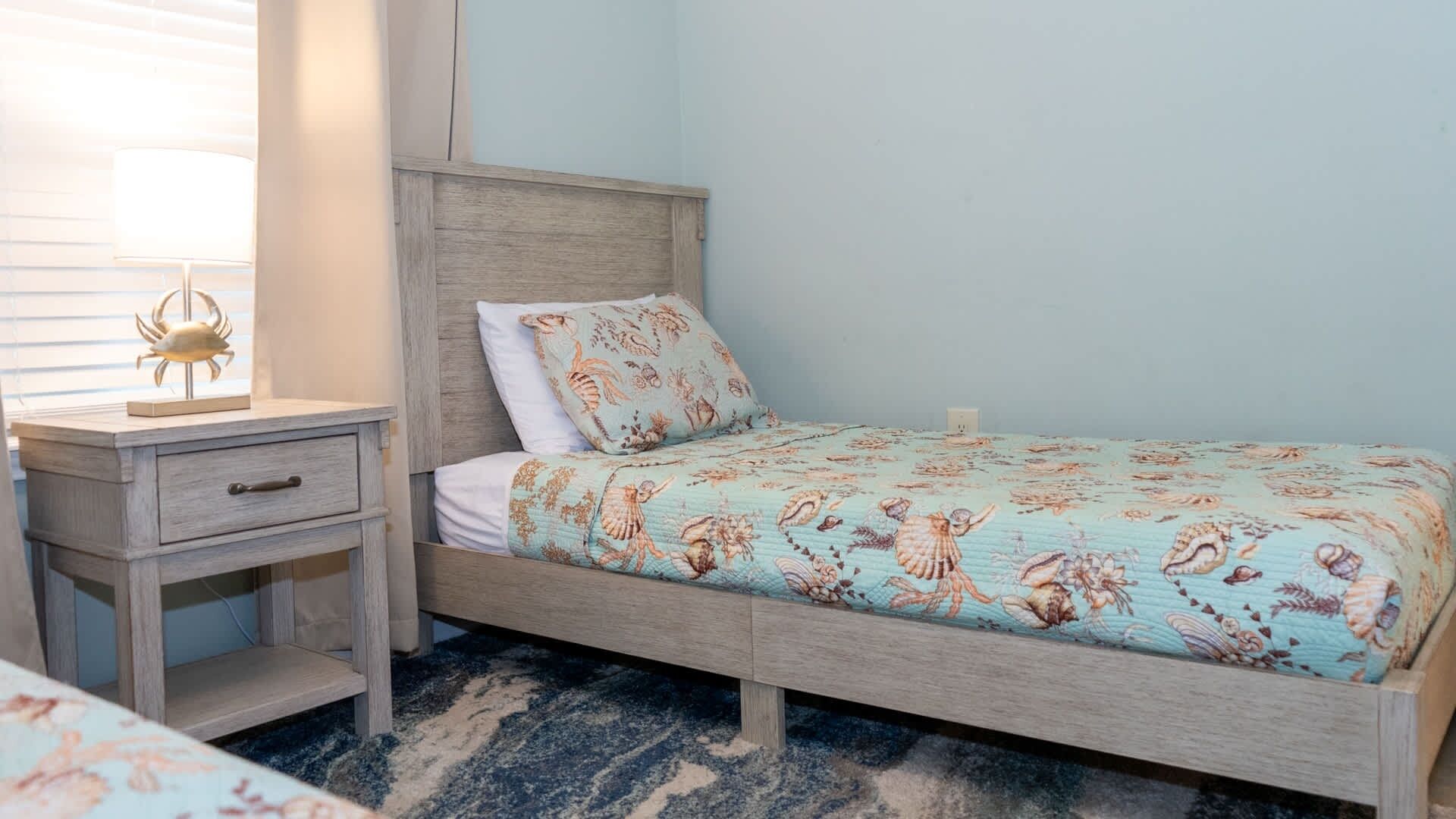 A bedroom with a bed, a nightstand, and a lamp.