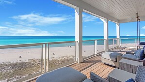 A covered outdoor deck with a view of a beach and ocean. - Best of the Best! Gulf Front with Heated Pool, Private Gym, Private Elevator (Panama City Beach)
